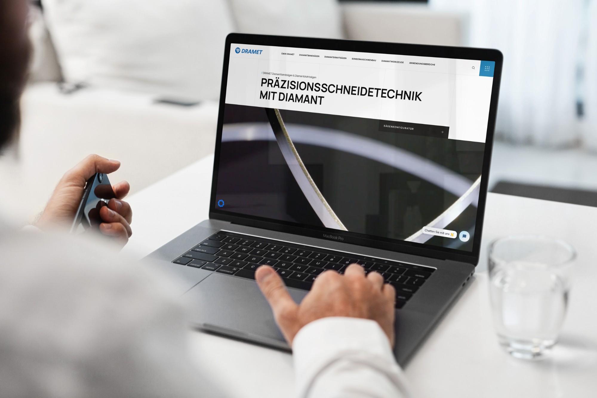 Person arbeitet an einem MacBook, auf dem die von uns gestaltete Website von DRAMET zu sehen ist